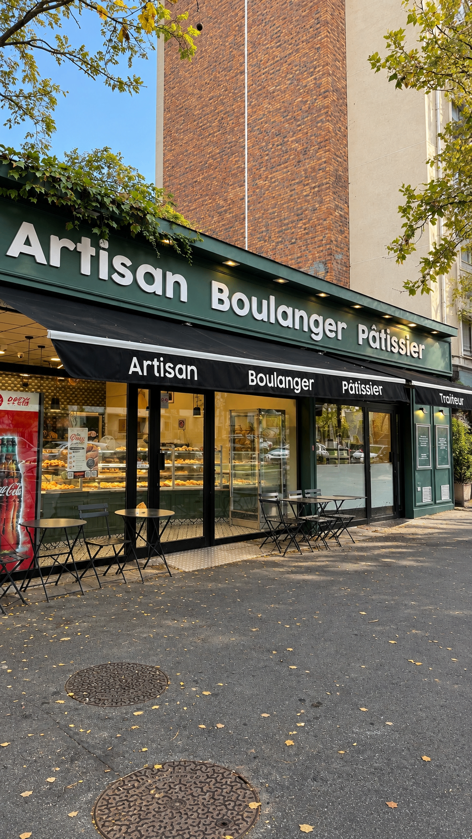 Façade verte de la boulangerie avec ses vitrines et sa terrasse